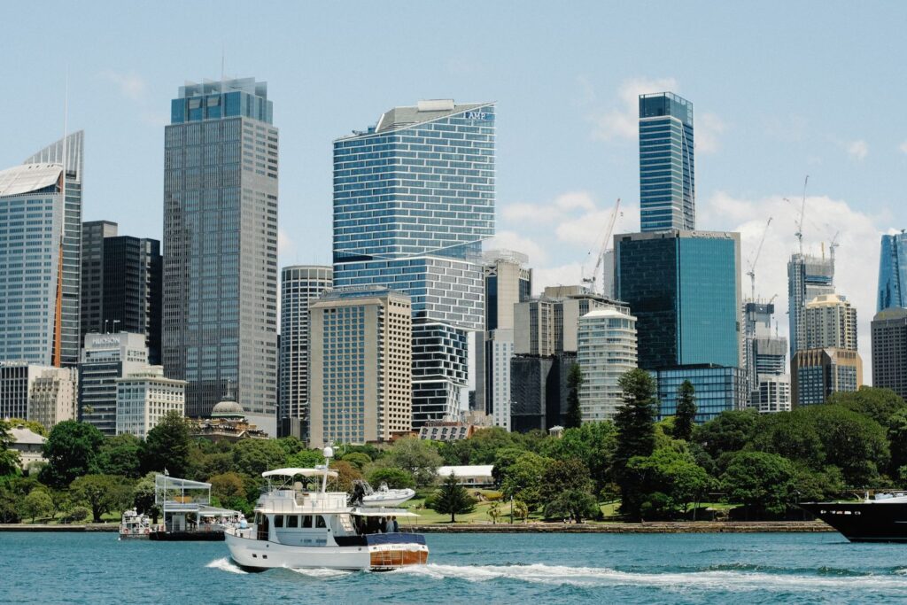 Sydney harbour skyline with parkland and a boat in the foreground