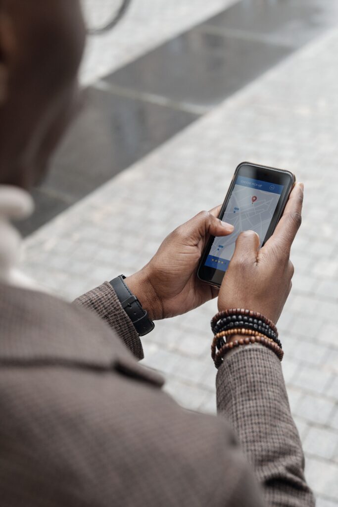 A man checks GPS directions on a smartphone on a city street