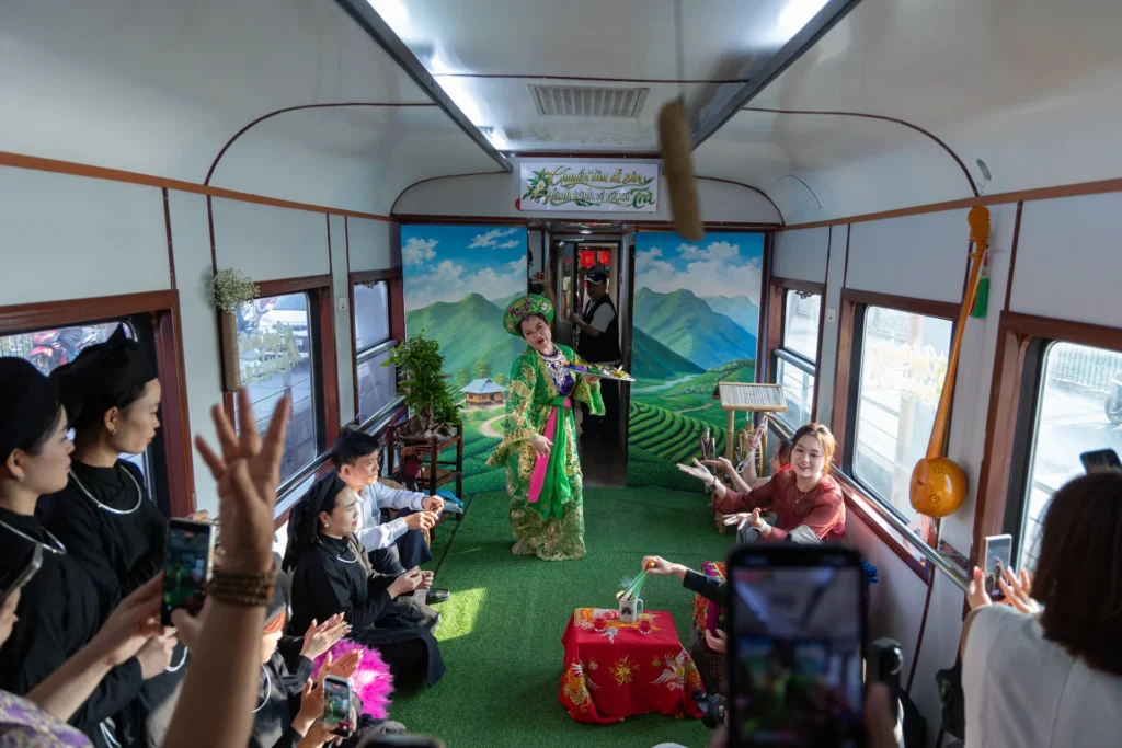 A performer presents a folk performance inside a train carriage.