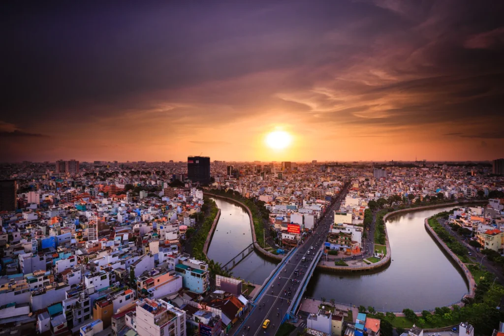 Ho Chi Minh City skyline and the Saigon River at sunset.