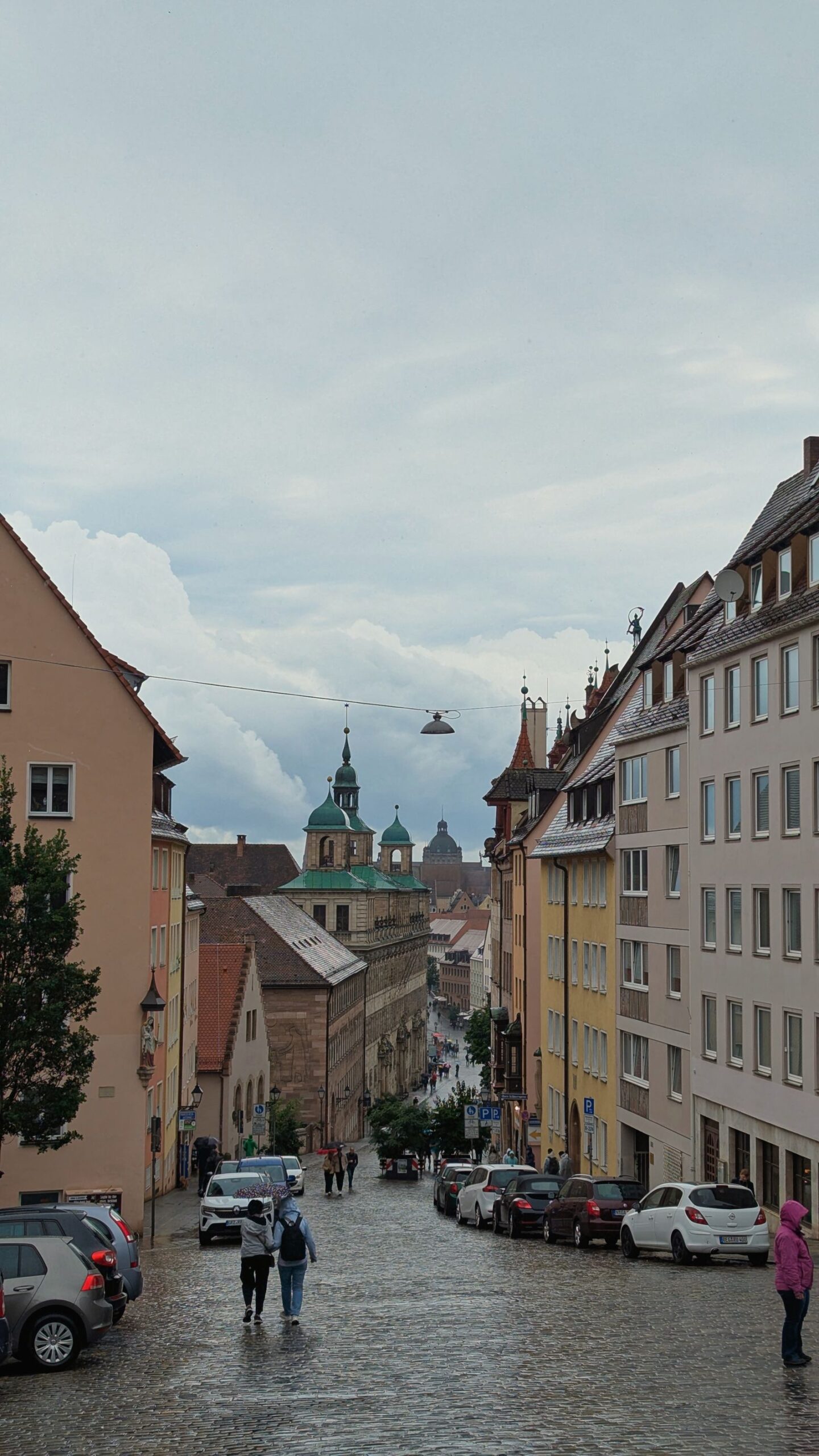 Wet cobbled street between historic buildings in Nuremberg Old Town.