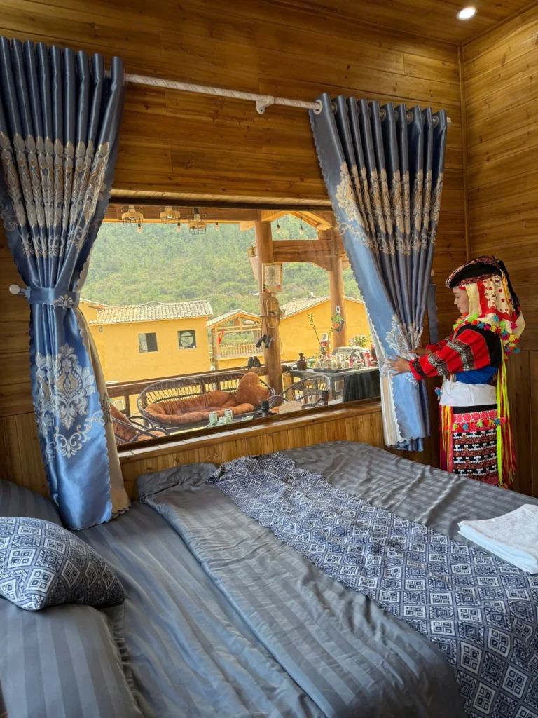 A bed and large windows inside a newly built Lo Lo Chai house.