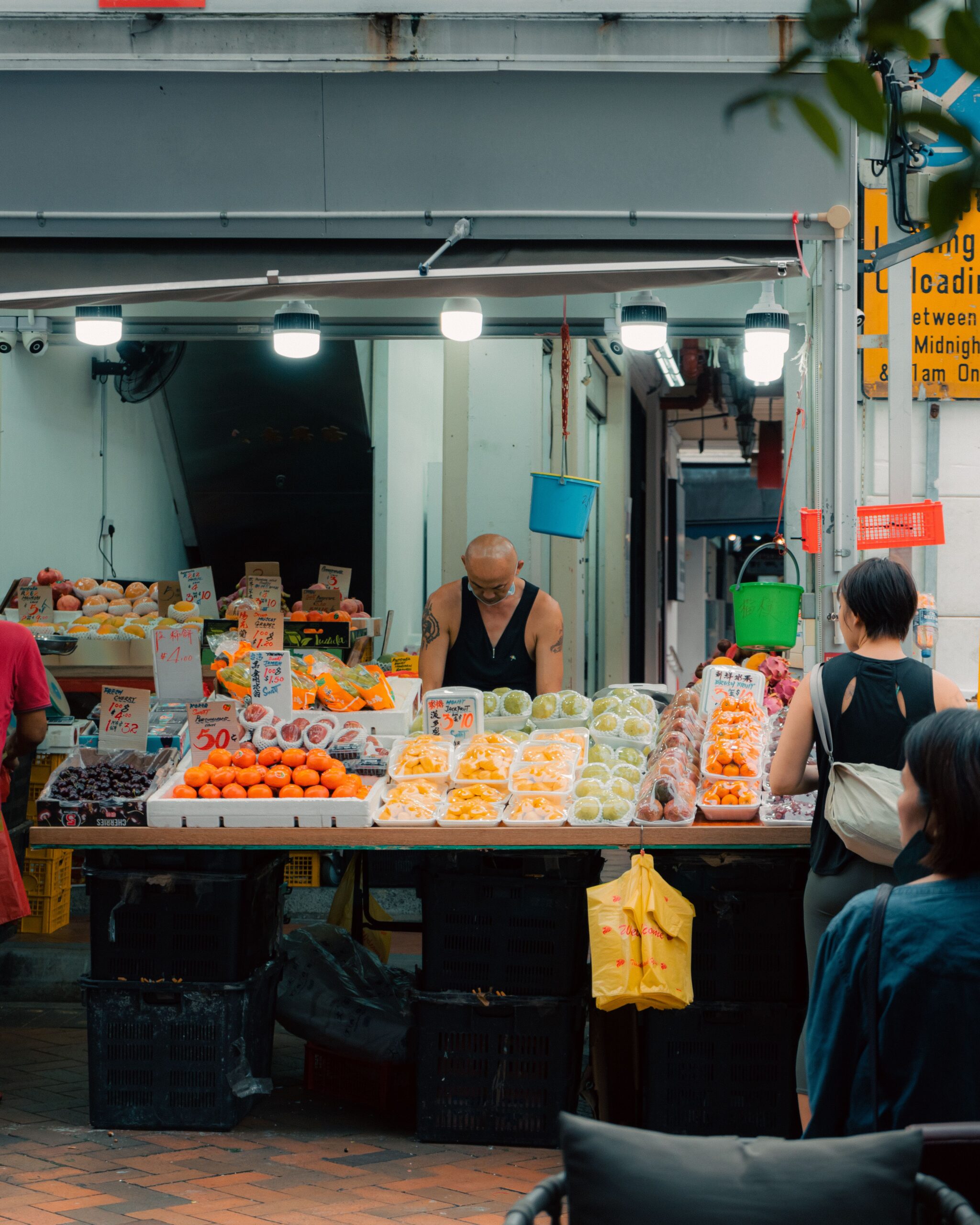 Singapore fruit stall displaying produce with shoppers