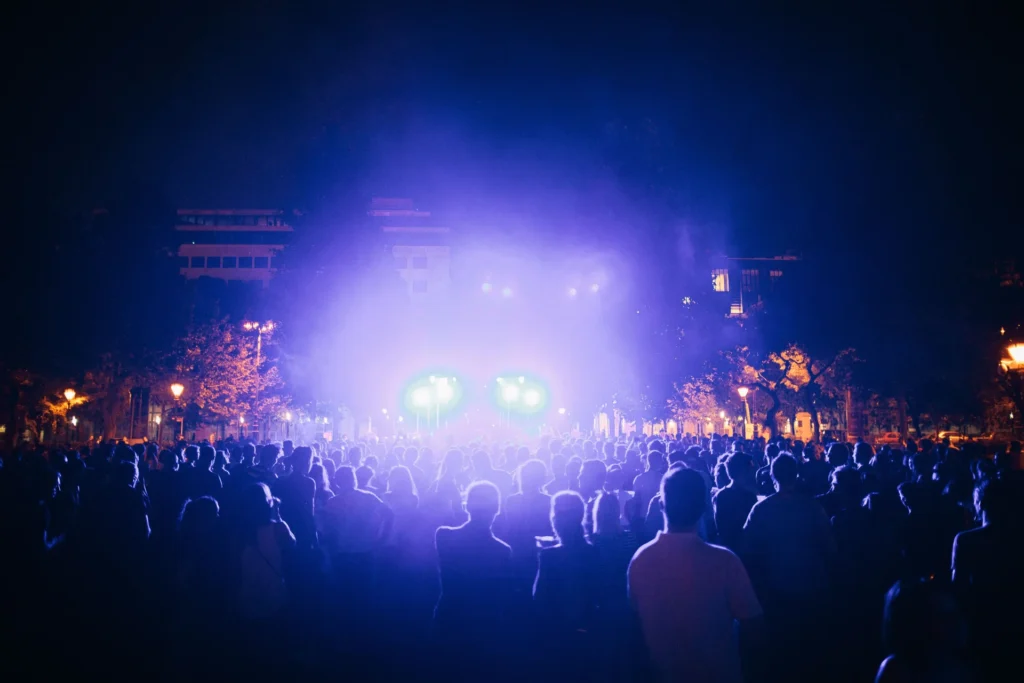 A crowd gathered at an outdoor concert after dark.