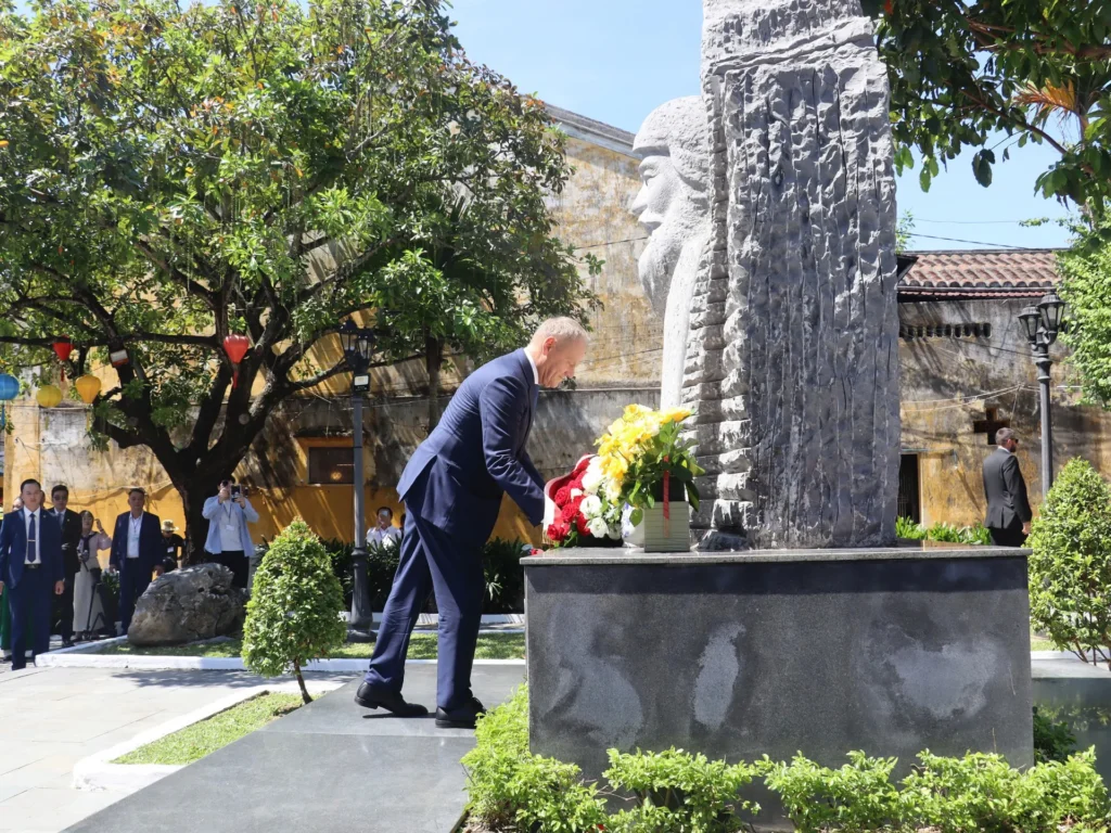 Polish Prime Minister Donald Tusk places flowers at the Kazimierz Kwiatkowski monument in Hoi An.