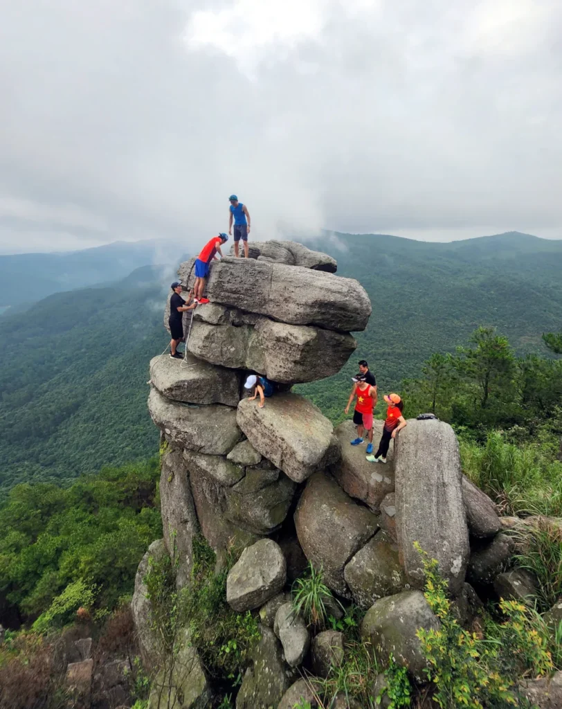 Tourists climb stacked rocks at Da Chong Mountain in Quang Ninh.