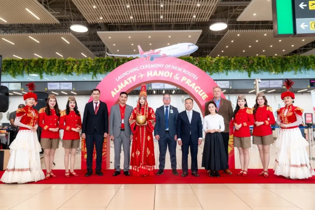 Airport guests stand beneath the launch-ceremony sign for Vietjet’s Hanoi–Prague route.
