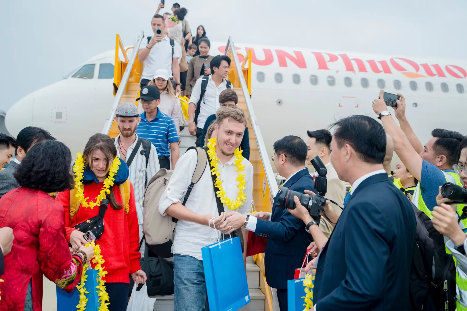 Travelers disembark from an aircraft during an arrival welcome.