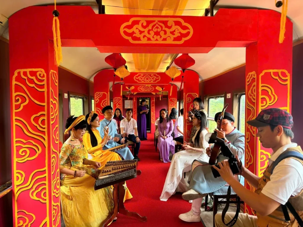 People perform music inside a decorated train carriage.