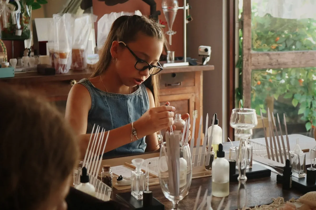 A participant working with perfume bottles and blending tools