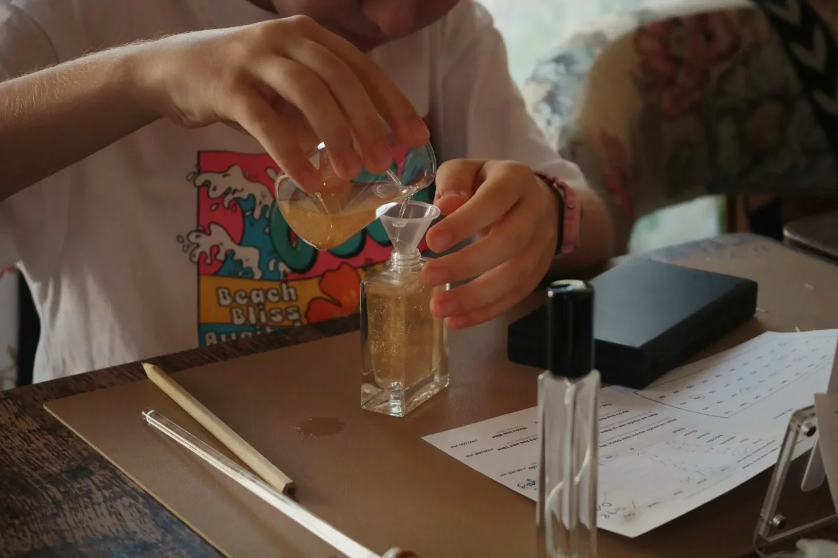 Close-up of fragrance being poured into a perfume bottle