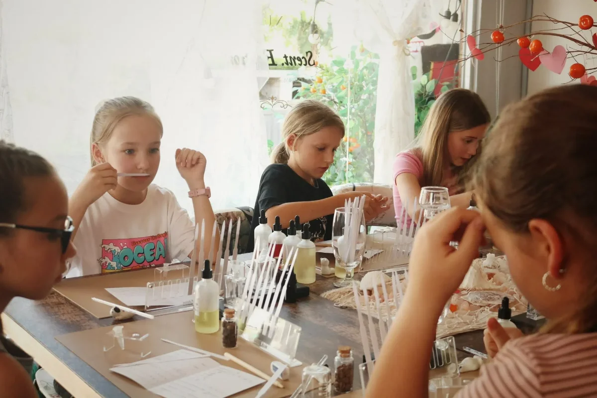 Participants creating fragrances around a perfume workshop table