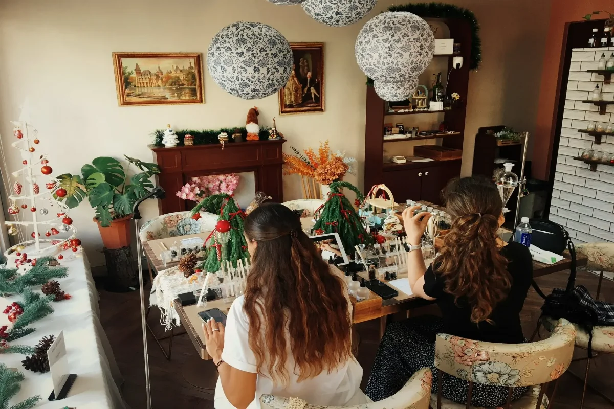 Guests at a perfume workshop table in a warmly decorated studio